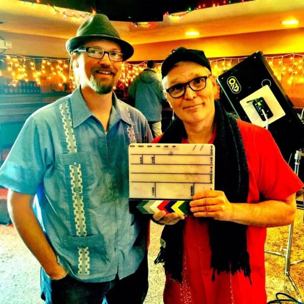 Jason Wussow and Veikko Lepisto, promo photo with string lights and a film clapperboard